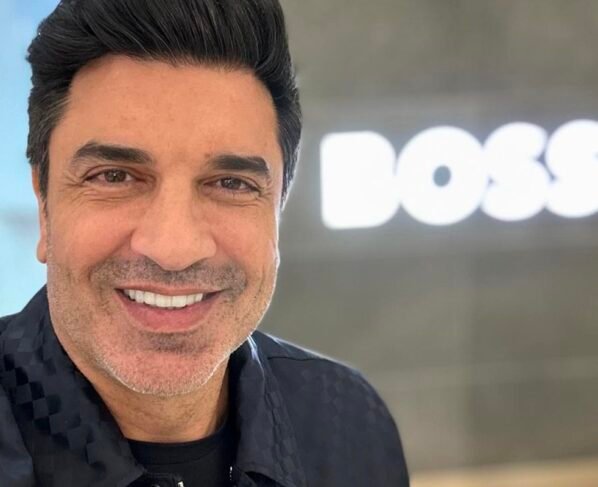 Edu Guedes posa sorridente para as redes sociais com a palavra 'boss' ao fundo - Metrópoles