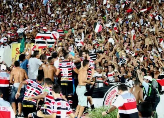 Foto colorida da torcida do Santa Cruz comemorando - Metrópoles