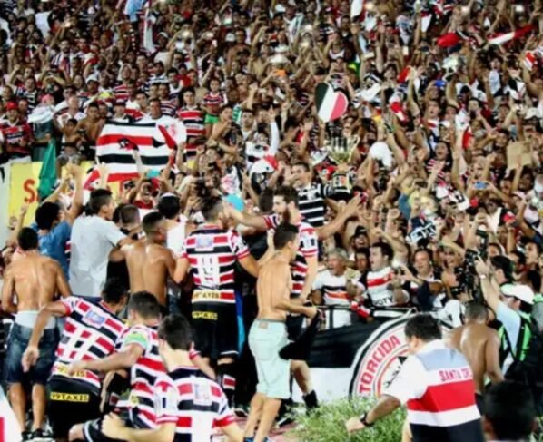 Foto colorida da torcida do Santa Cruz comemorando - Metrópoles