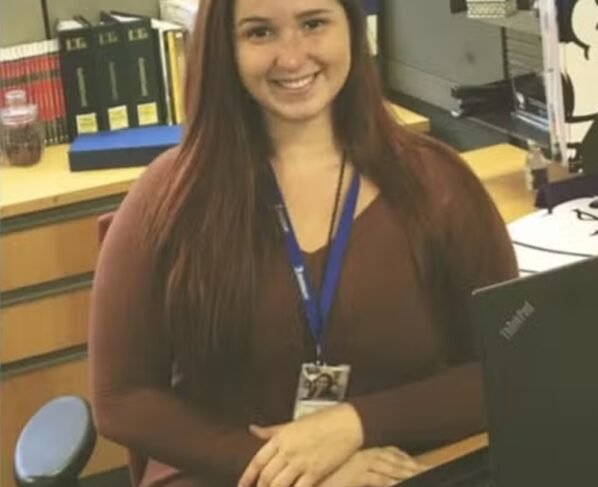 Mulher de cabelo longo e crachá em escritório