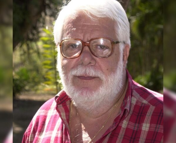 foto colorida de homem branco de barba branca e oculos de grau vestindo blusa xadrez vermelha - metrópoles