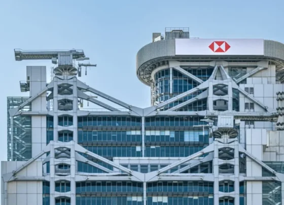 Foto do topo do prédio do HSBC em Hong Kong, com um céu azul limpo ao fundo.