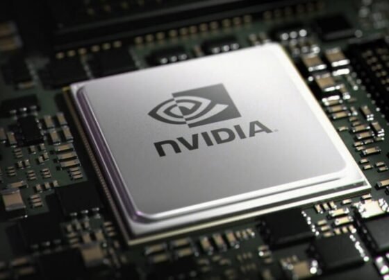 Imagem mostra um chip de computador prateado, com o logo e o nome "NVIDIA" em preto, centralizado em uma placa-mãe escura cheia de pequenos componentes eletrônicos.