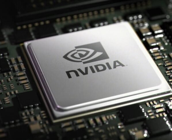 Imagem mostra um chip de computador prateado, com o logo e o nome "NVIDIA" em preto, centralizado em uma placa-mãe escura cheia de pequenos componentes eletrônicos.