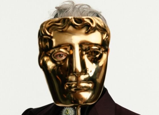 Alan Cumming com um prêmio Bafta nas mãos