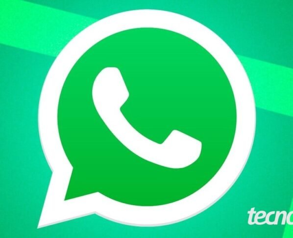 Imagem mostra o logo do WhatsApp ao centro, sobre um fundo verde com faixas diagonais em verde mais claro. O logo consiste em um balão de diálogo branco com um contorno verde mais escuro, contendo um ícone de telefone branco dentro. Na parte inferior direita, o logotipo do "Tecnoblog" é visível, em fonte de cor branca.