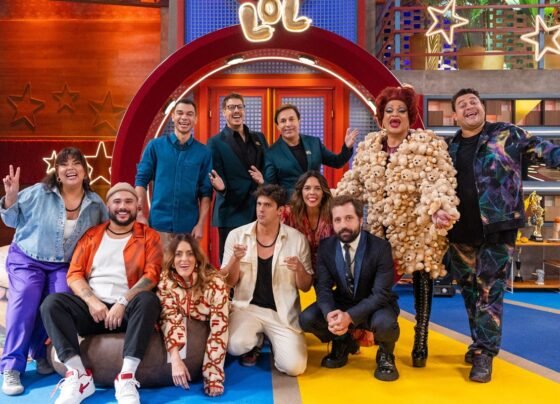 Elenco da 5ª temporada de LOL Brasil em frente ao cenário - Metrópoles