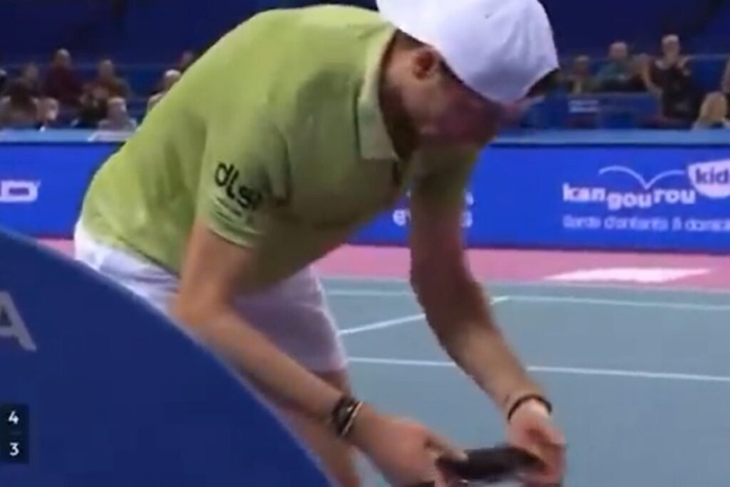 Tenista com celular na mão - Metrópoles