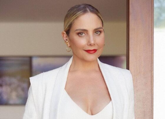 foto de uma mulher loira, branca, usando batom vermelho. ela usa look branco - Metrópoles