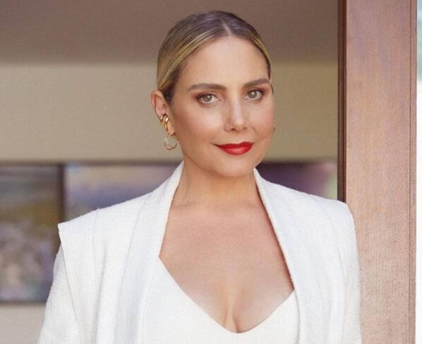 foto de uma mulher loira, branca, usando batom vermelho. ela usa look branco - Metrópoles